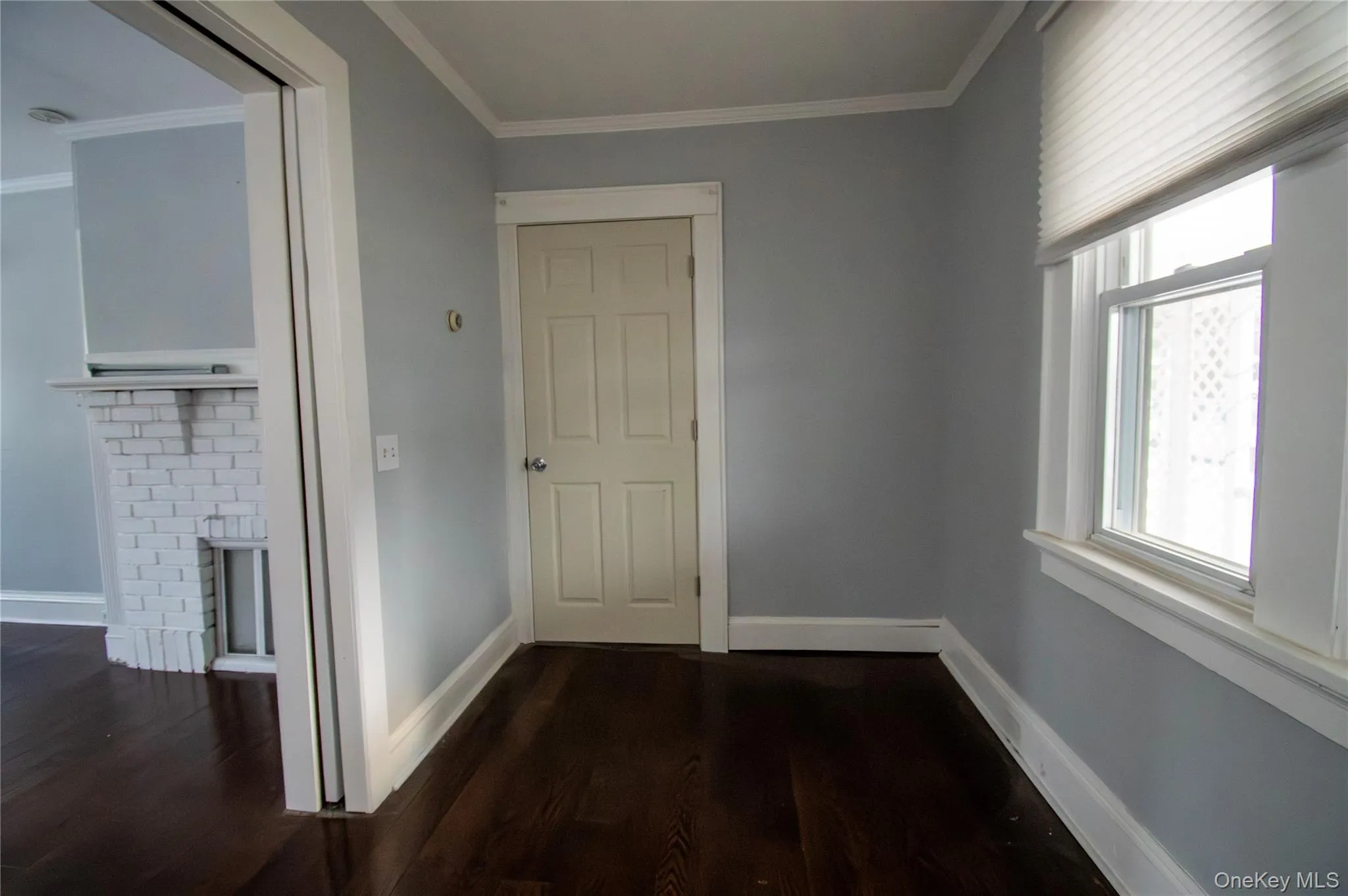 Hall with crown molding and dark wood finished floors Hall with crown molding and dark wood finished floors