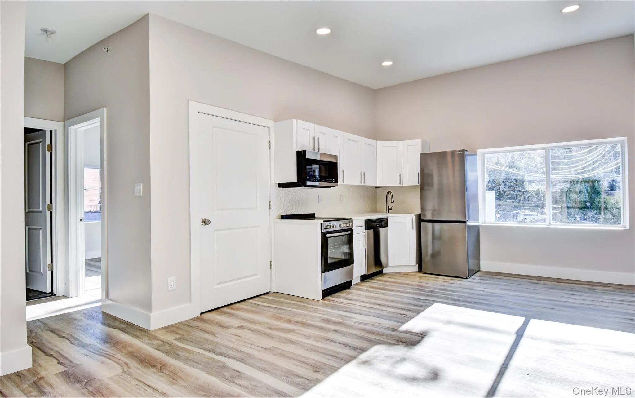 Kitchen with light countertops, white cabinetry, appliances with stainless steel finishes, healthy amount of natural light, and recessed lighting Kitchen with light countertops, white cabinetry, appliances with stainless steel finishes, healthy amount of natural light, and recessed lighting