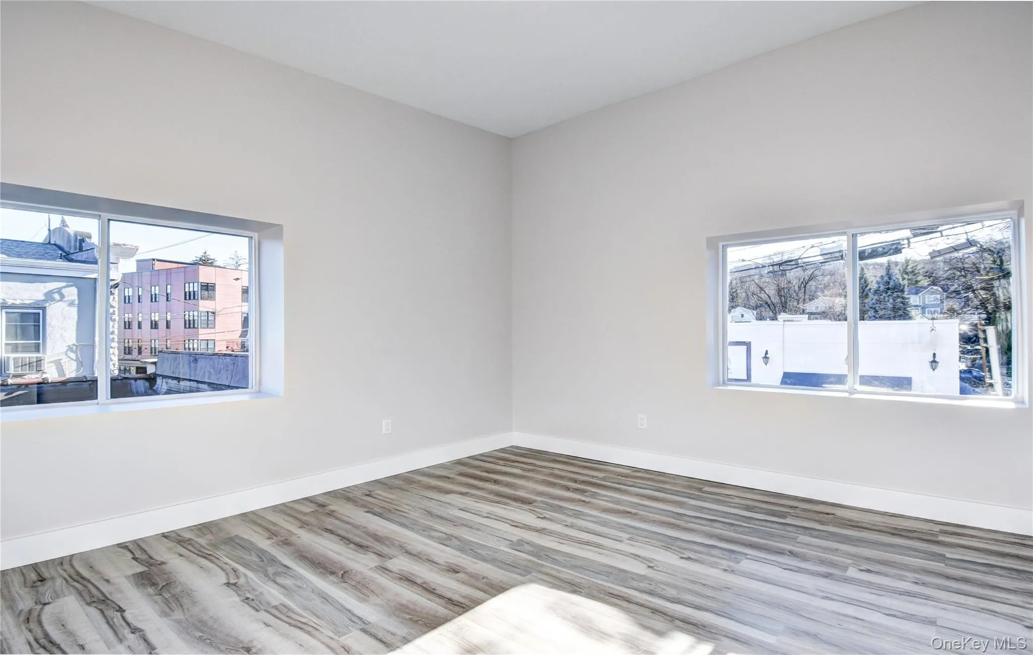 Spare room featuring wood finished floors and plenty of natural light Spare room featuring wood finished floors and plenty of natural light