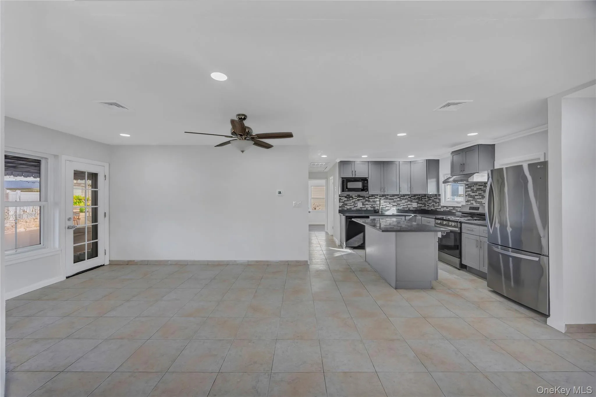 Kitchen featuring gray cabinets, appliances with stainless steel finishes, recessed lighting, a center island, and a ceiling fan Kitchen featuring gray cabinets, appliances with stainless steel finishes, recessed lighting, a center island, and a ceiling fan