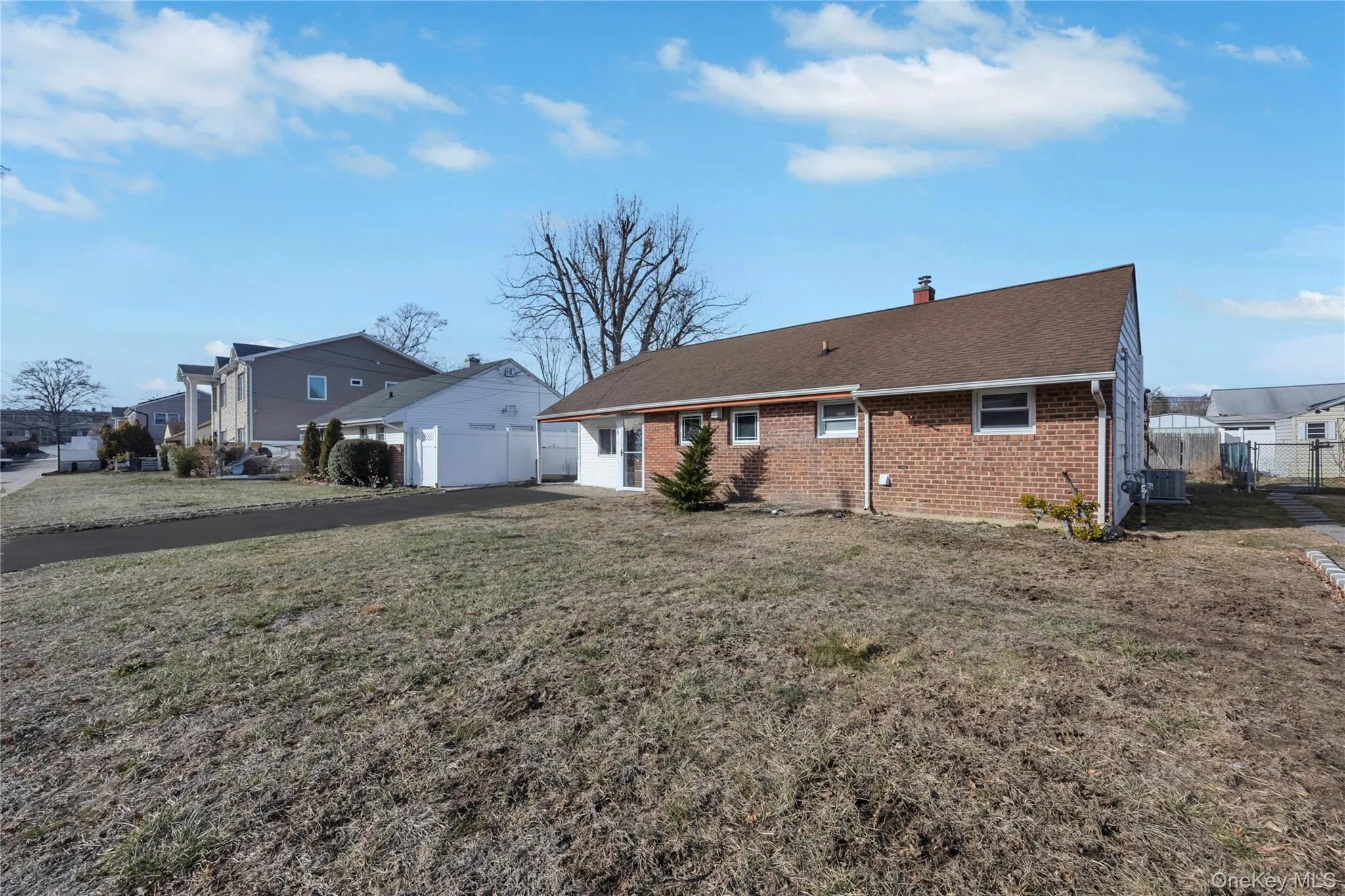 Back of house featuring brick siding, a chimney, and roof with shingles Back of house featuring brick siding, a chimney, and roof with shingles