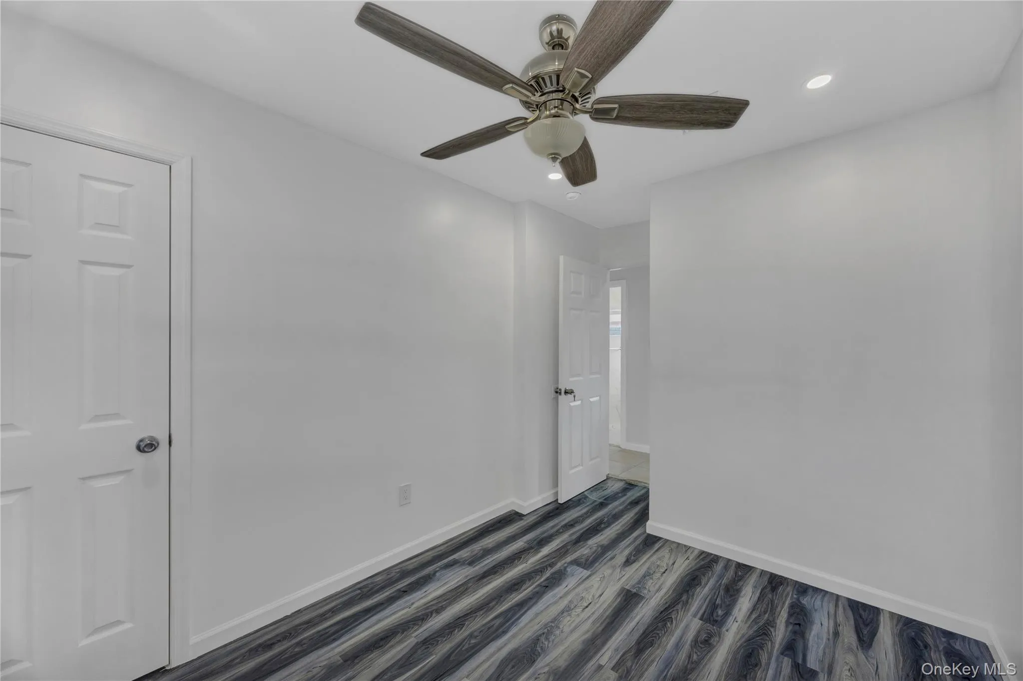 Spare room featuring dark wood-type flooring, recessed lighting, and a ceiling fan Spare room featuring dark wood-type flooring, recessed lighting, and a ceiling fan