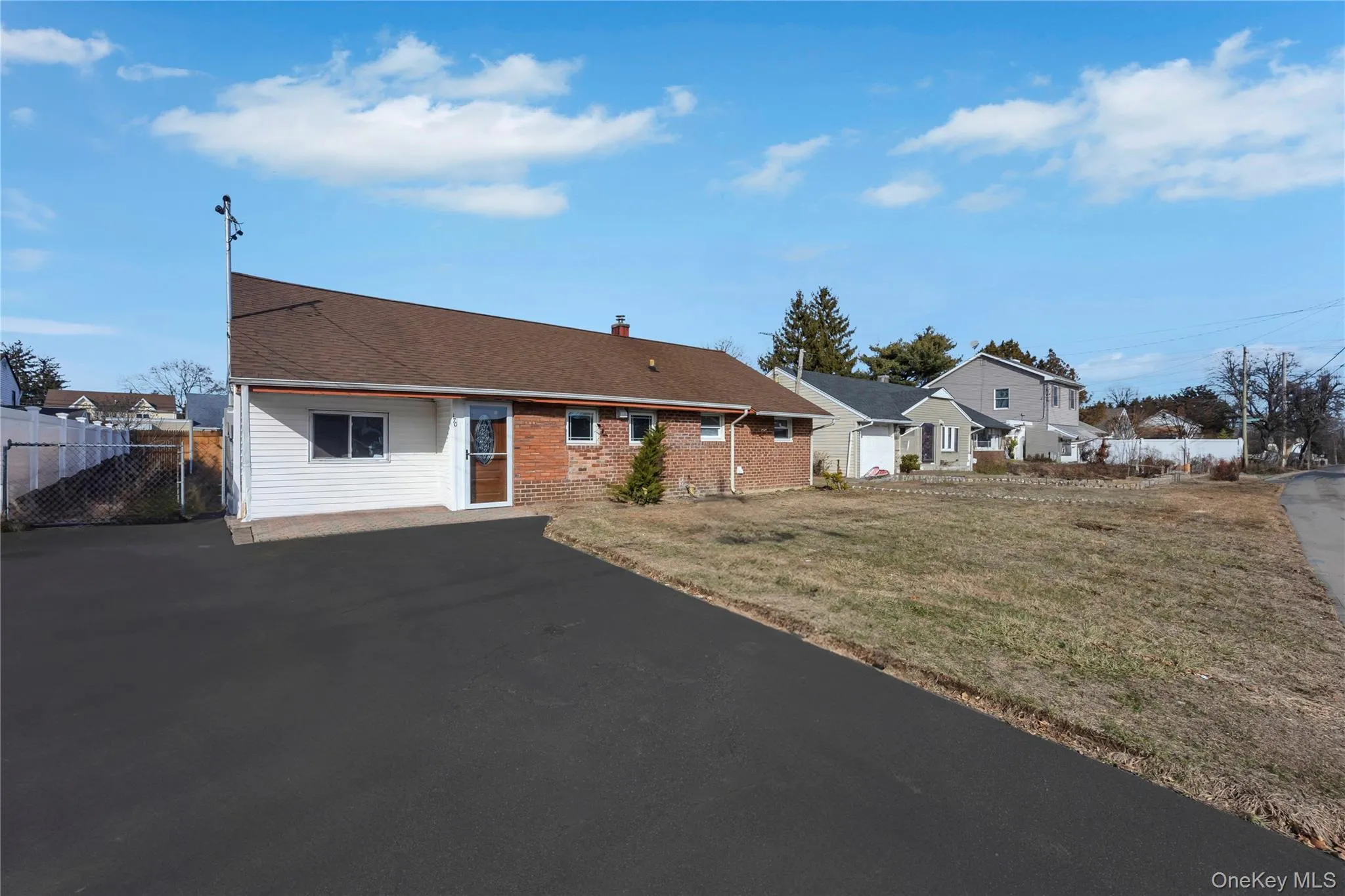 Ranch-style home with a chimney, a patio, roof with shingles, and brick siding Ranch-style home with a chimney, a patio, roof with shingles, and brick siding