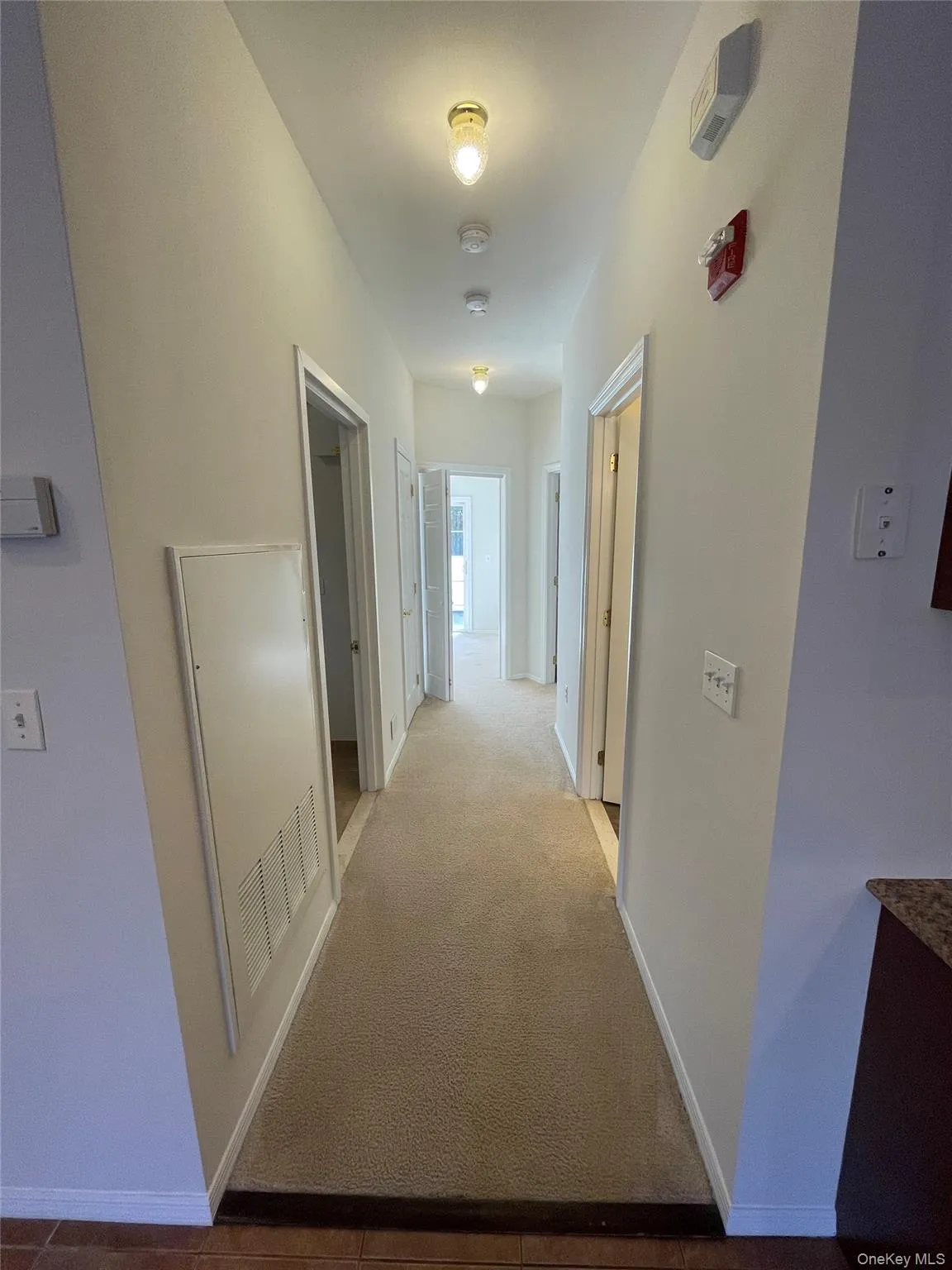Hallway with carpet flooring and a heating unit Hallway with carpet flooring and a heating unit
