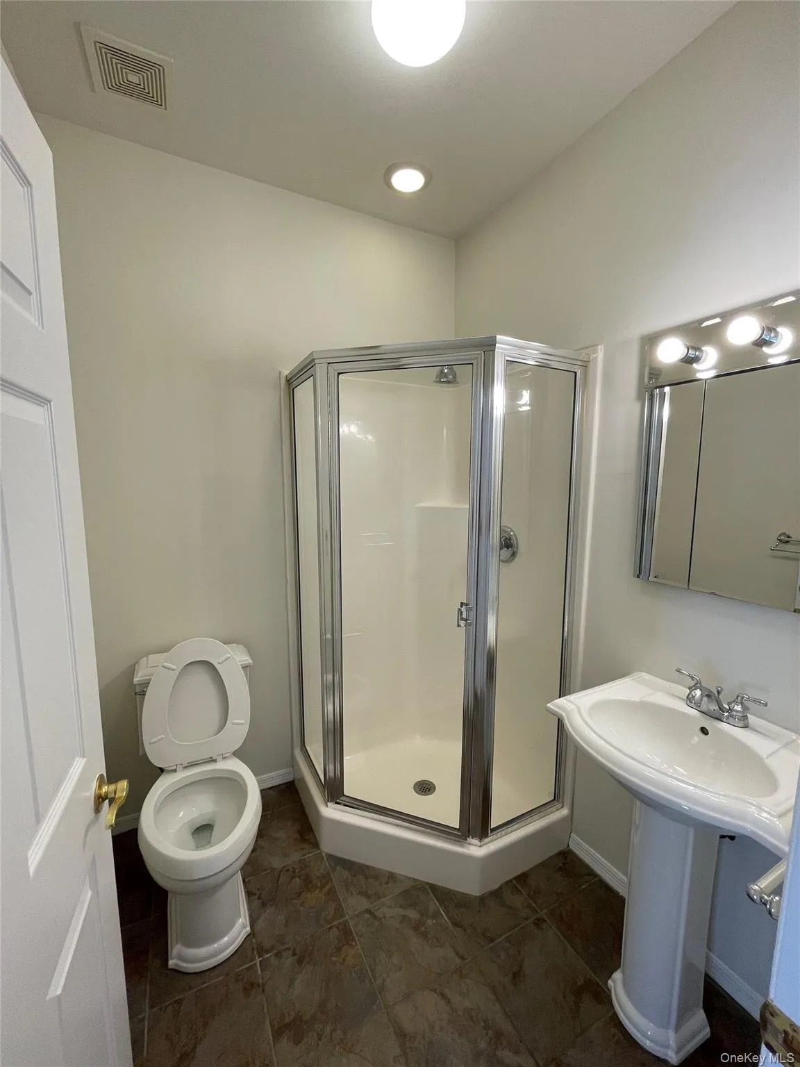 Full bathroom featuring a shower stall and toilet Full bathroom featuring a shower stall and toilet