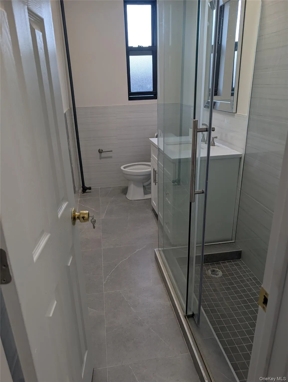 Full bathroom featuring vanity, a stall shower, and tile walls Full bathroom featuring vanity, a stall shower, and tile walls