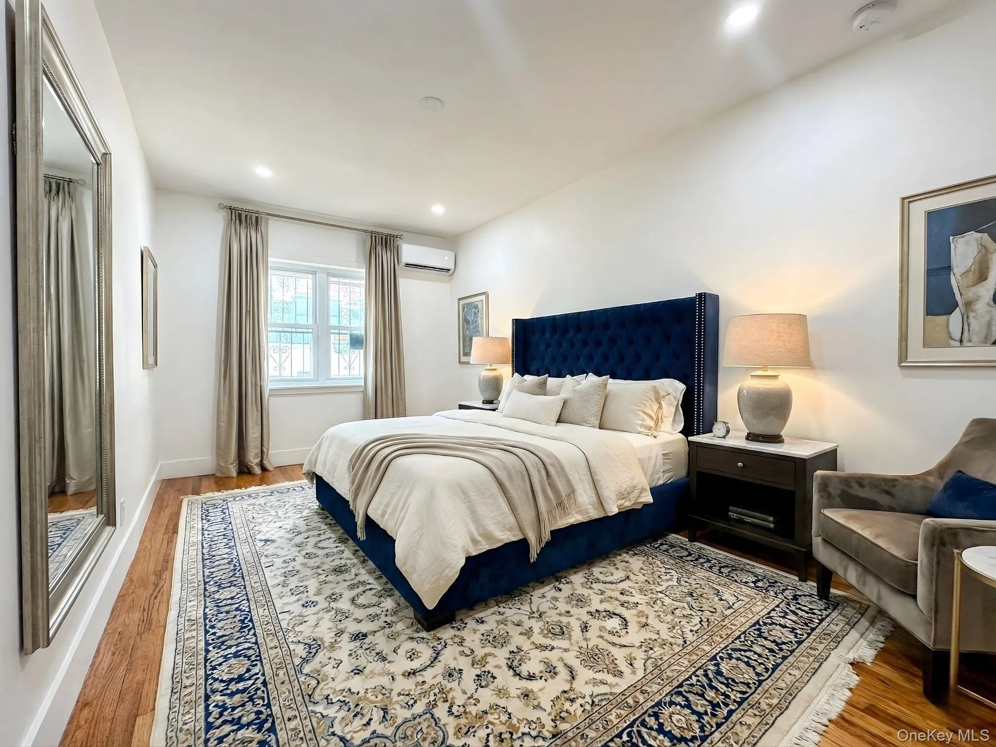Bedroom with wood finished floors, a wall mounted AC, and recessed lighting Bedroom with wood finished floors, a wall mounted AC, and recessed lighting