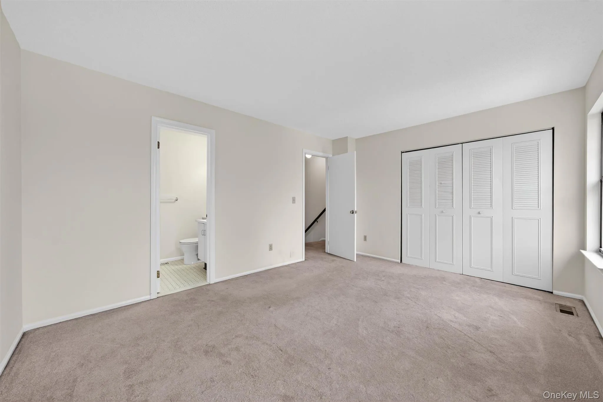 Unfurnished bedroom featuring light colored carpet and a closet Unfurnished bedroom featuring light colored carpet and a closet