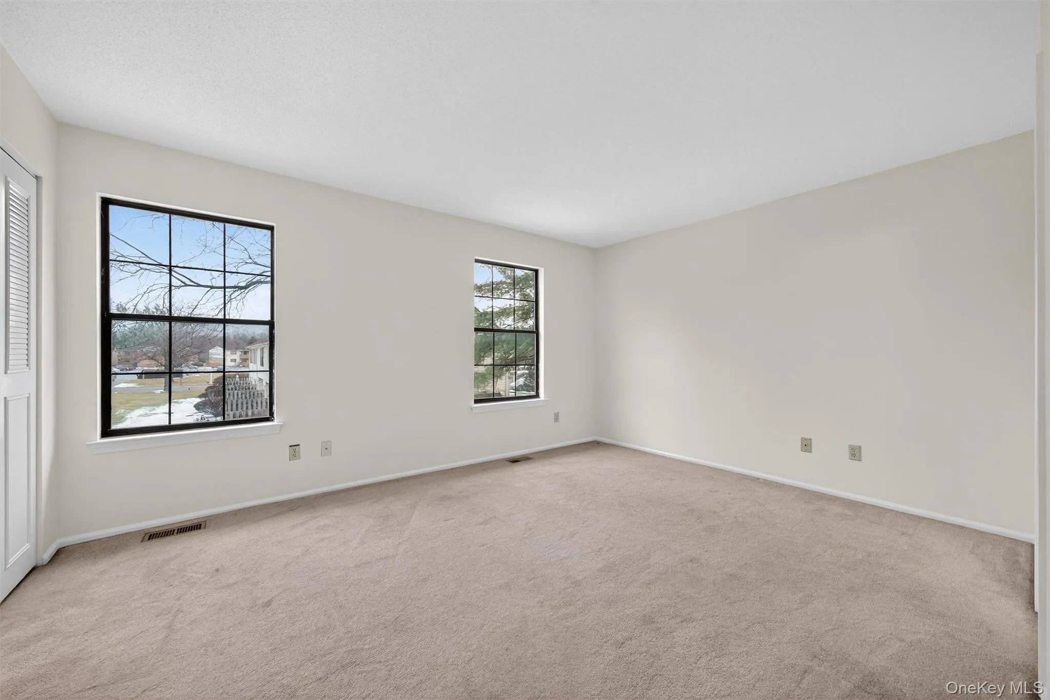 Empty room featuring light carpet and baseboards Empty room featuring light carpet and baseboards
