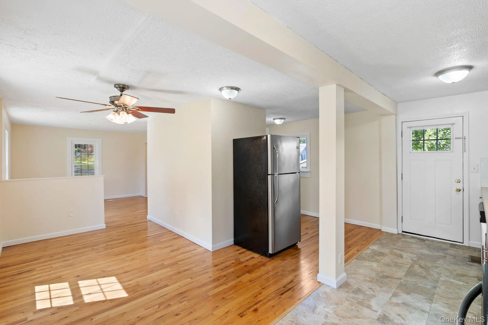 Entrance foyer with a textured ceiling, light wood-type flooring, and ceiling fan Entrance foyer with a textured ceiling, light wood-type flooring, and ceiling fan