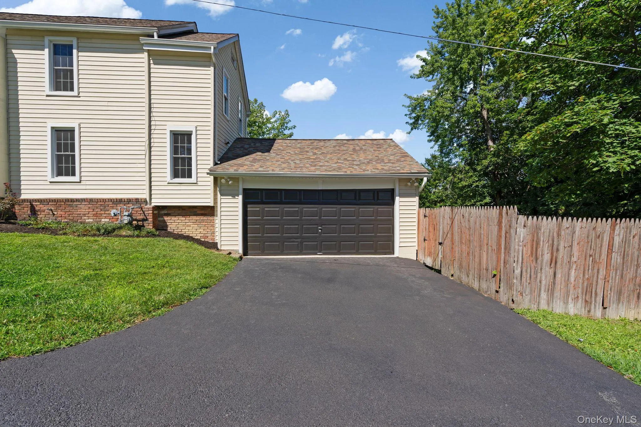 View of property exterior with a garage, roof with shingles, and brick siding View of property exterior with a garage, roof with shingles, and brick siding
