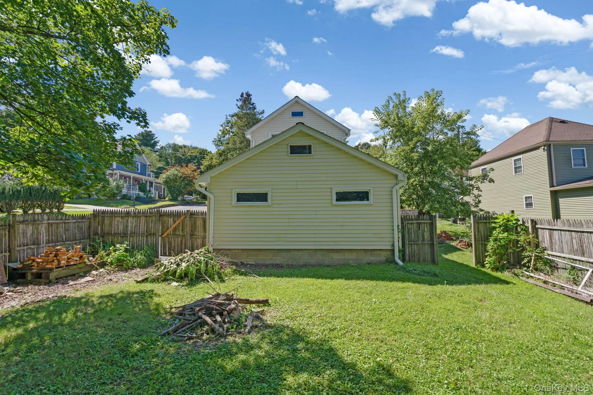 Back of property with a fenced backyard and an outdoor fire pit Back of property with a fenced backyard and an outdoor fire pit