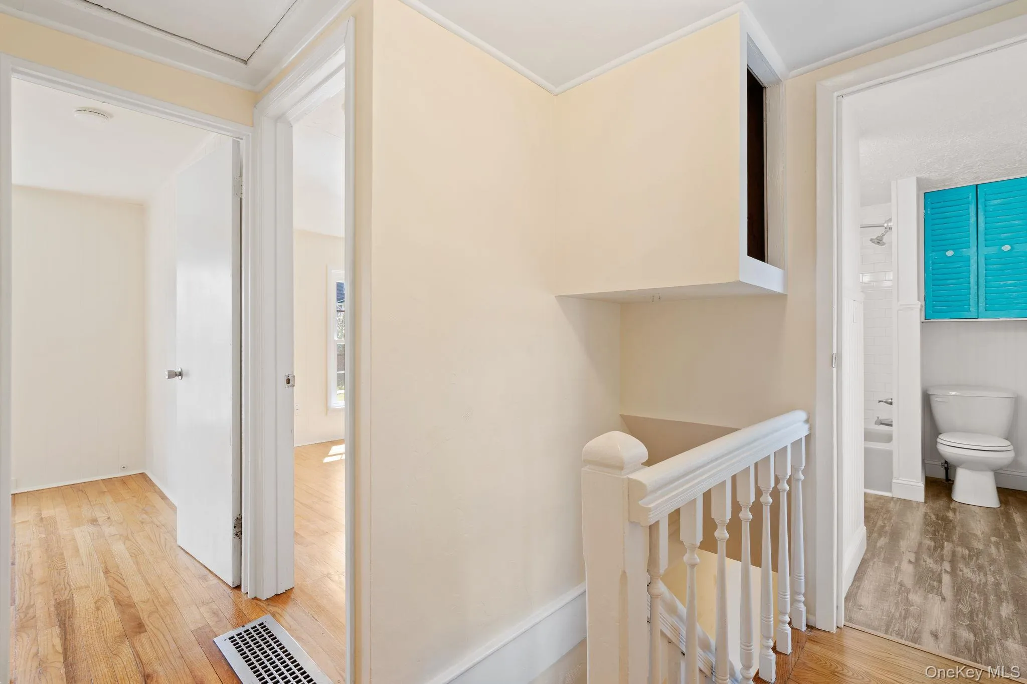 Hall with light wood finished floors, an upstairs landing, and crown molding Hall with light wood finished floors, an upstairs landing, and crown molding
