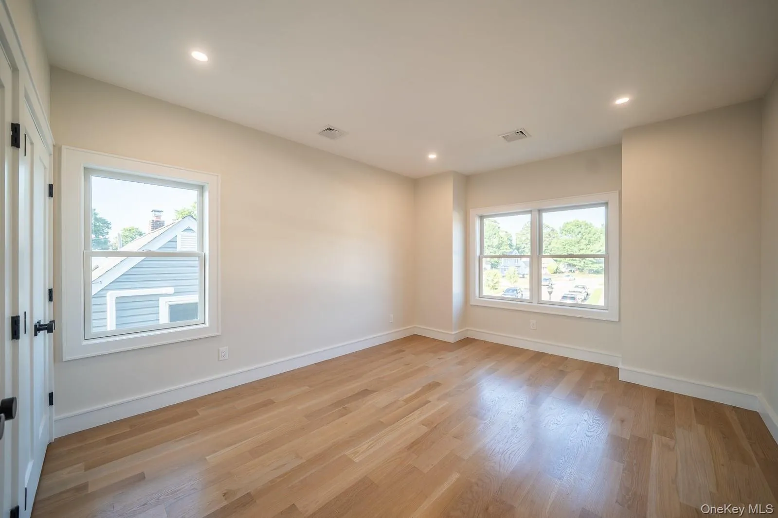 Empty room featuring healthy amount of natural light, light wood-style flooring, and recessed lighting Empty room featuring healthy amount of natural light, light wood-style flooring, and recessed lighting