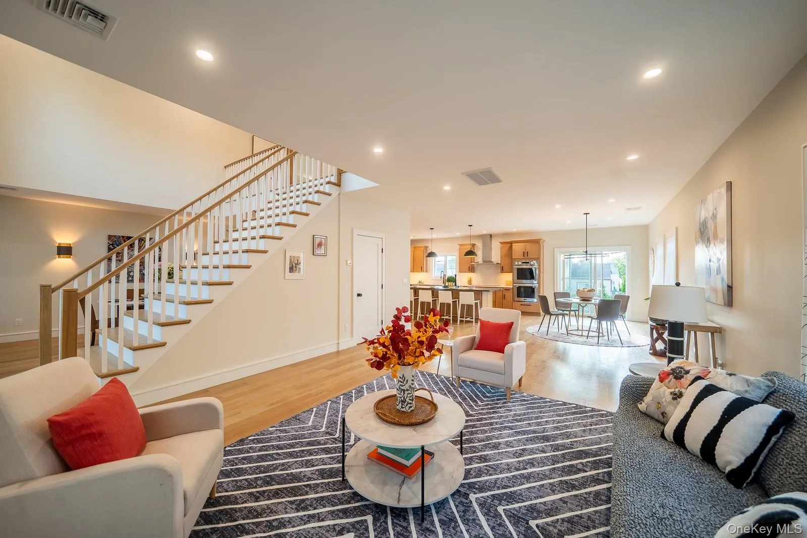 Living area featuring stairs, light wood-style floors, and recessed lighting Living area featuring stairs, light wood-style floors, and recessed lighting