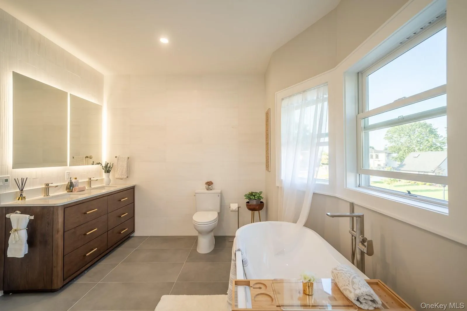 Full bathroom with a soaking tub, vanity, tile walls, and tile patterned flooring Full bathroom with a soaking tub, vanity, tile walls, and tile patterned flooring