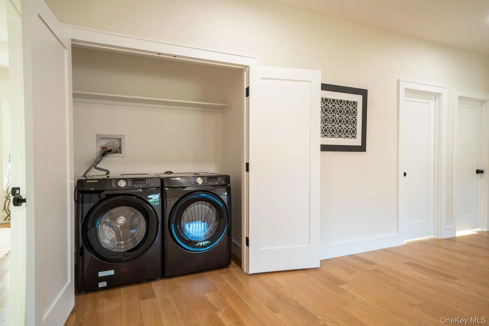 Laundry room featuring wood finished floors and washing machine and clothes dryer Laundry room featuring wood finished floors and washing machine and clothes dryer
