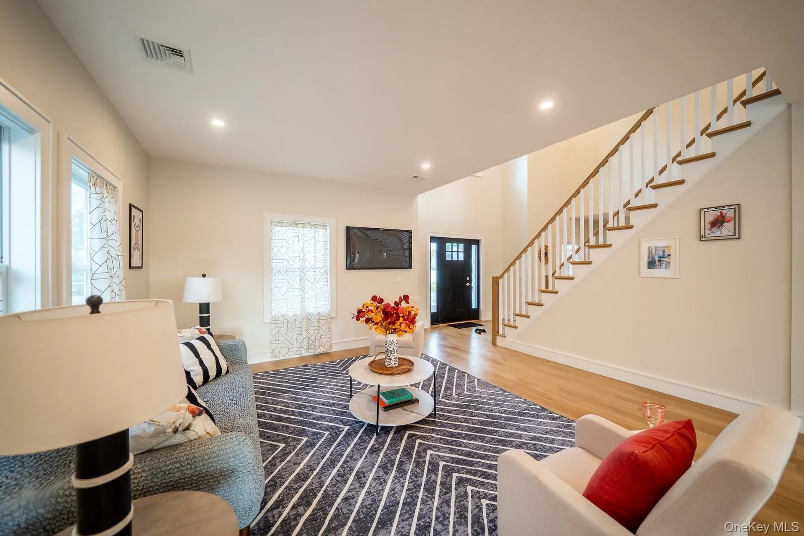 Living area with stairs, wood finished floors, and recessed lighting Living area with stairs, wood finished floors, and recessed lighting