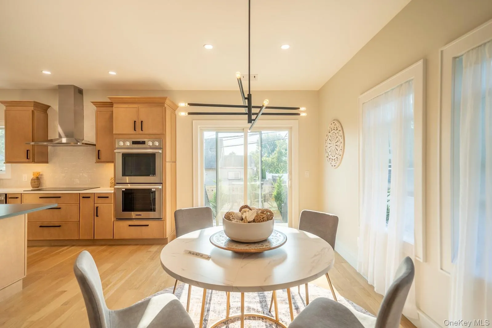 Dining space with light wood-style floors, a chandelier, and recessed lighting Dining space with light wood-style floors, a chandelier, and recessed lighting