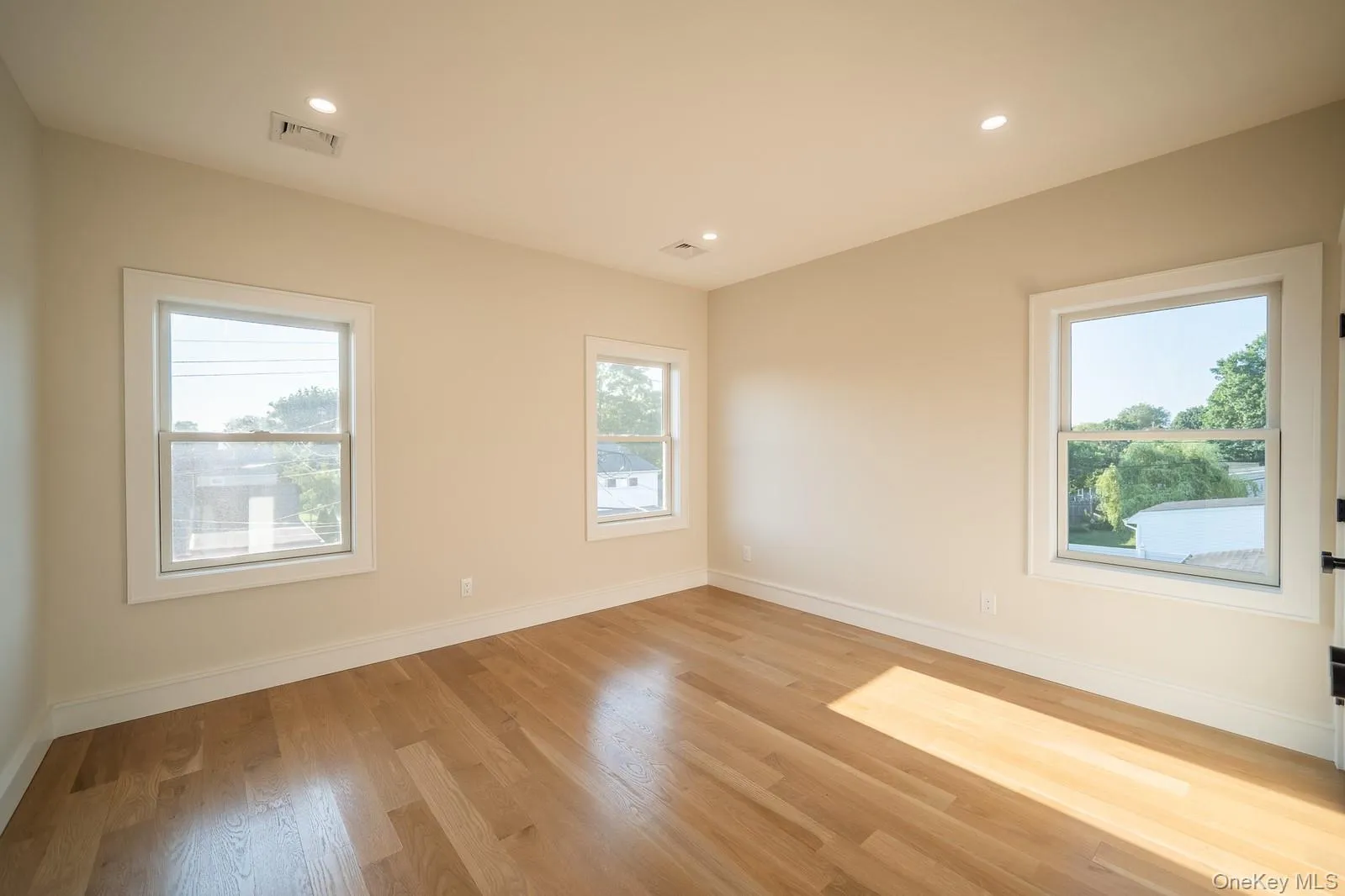 Unfurnished room with plenty of natural light, light wood-style flooring, and recessed lighting Unfurnished room with plenty of natural light, light wood-style flooring, and recessed lighting
