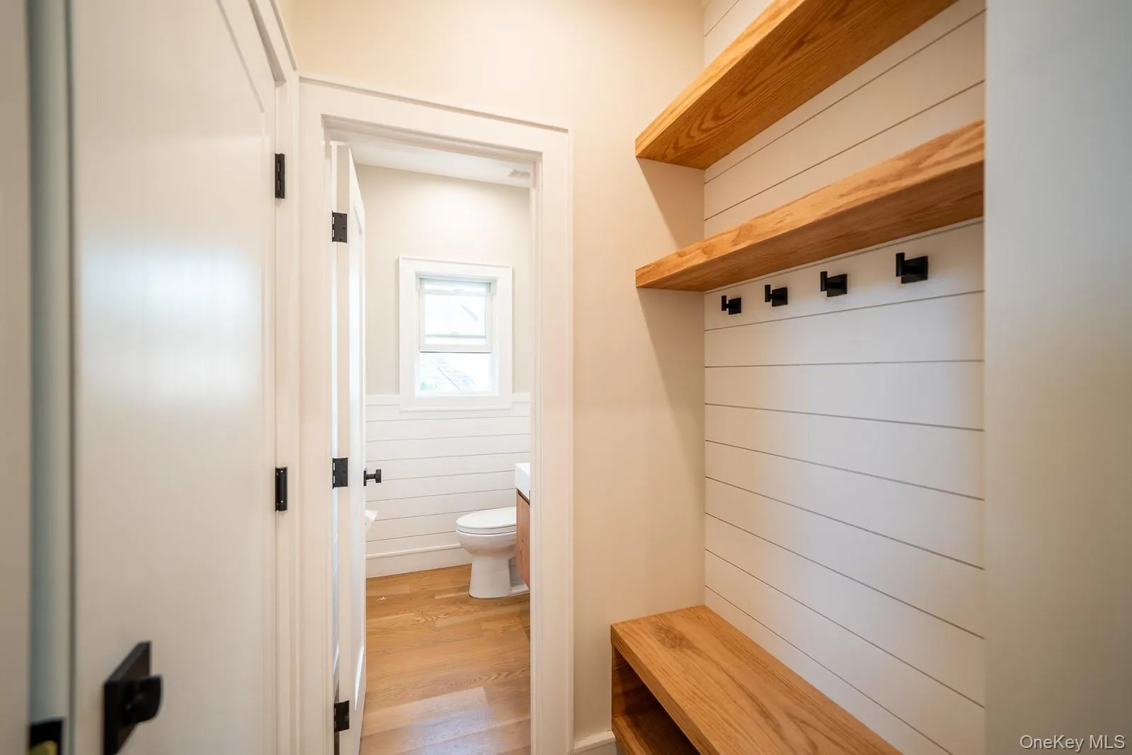 Mudroom with a wainscoted wall and wood finished floors Mudroom with a wainscoted wall and wood finished floors