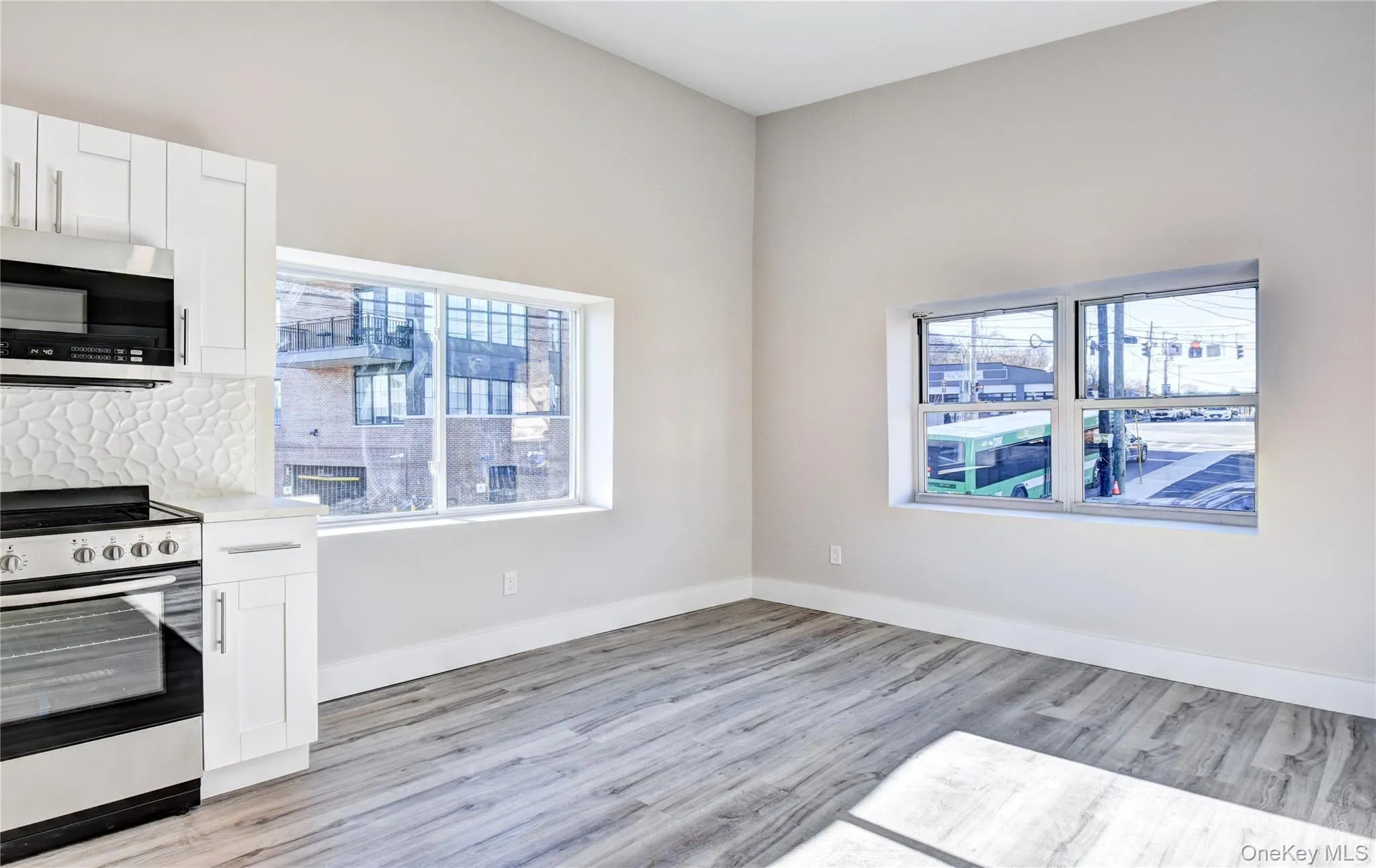 Kitchen with appliances with stainless steel finishes, white cabinetry, plenty of natural light, and light wood finished floors Kitchen with appliances with stainless steel finishes, white cabinetry, plenty of natural light, and light wood finished floors