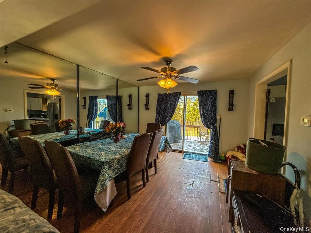 Dining room featuring wood-type flooring and ceiling fan Dining room featuring wood-type flooring and ceiling fan