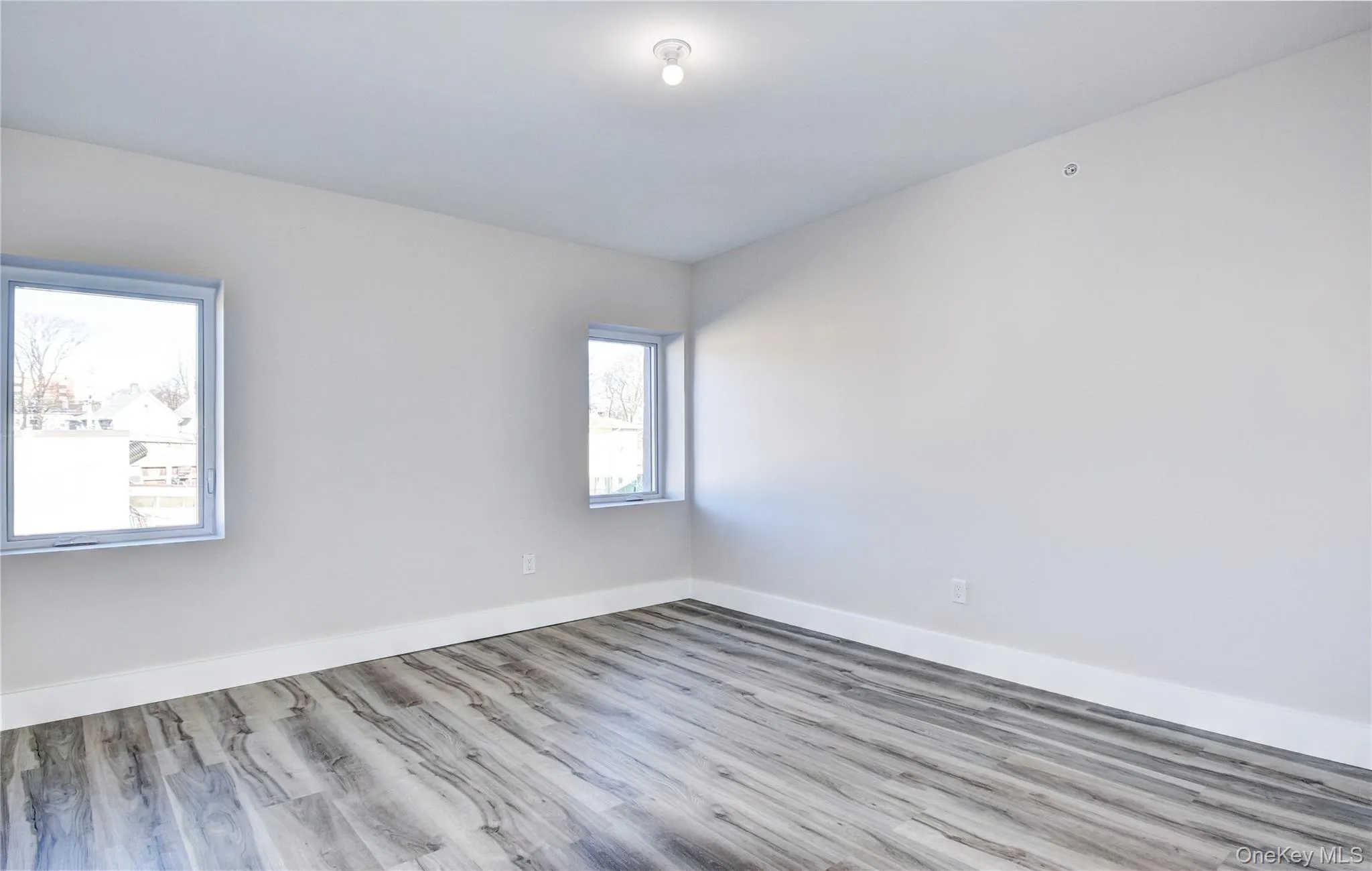 Unfurnished room featuring wood finished floors and baseboards Unfurnished room featuring wood finished floors and baseboards