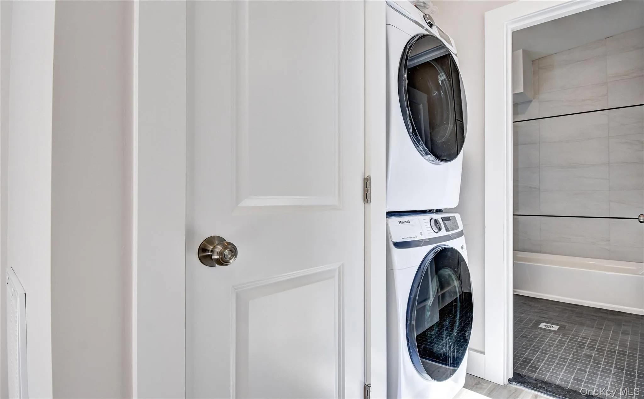 Laundry area with stacked washing machine and dryer Laundry area with stacked washing machine and dryer
