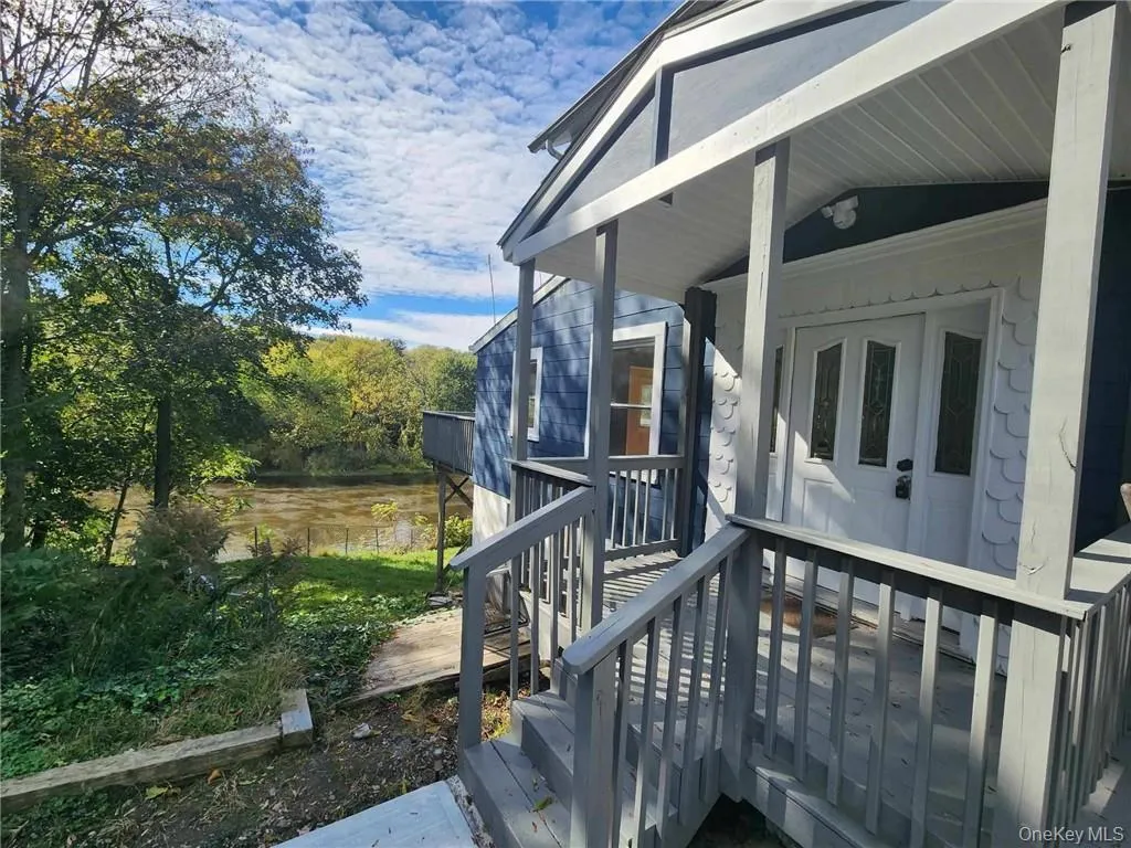View of side of home featuring a deck with water view View of side of home featuring a deck with water view