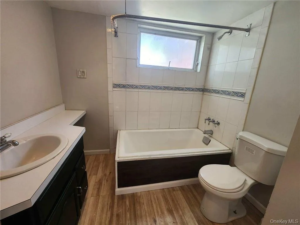 Bathroom featuring vanity, shower / bathtub combination, and light wood-style floors Bathroom featuring vanity, shower / bathtub combination, and light wood-style floors