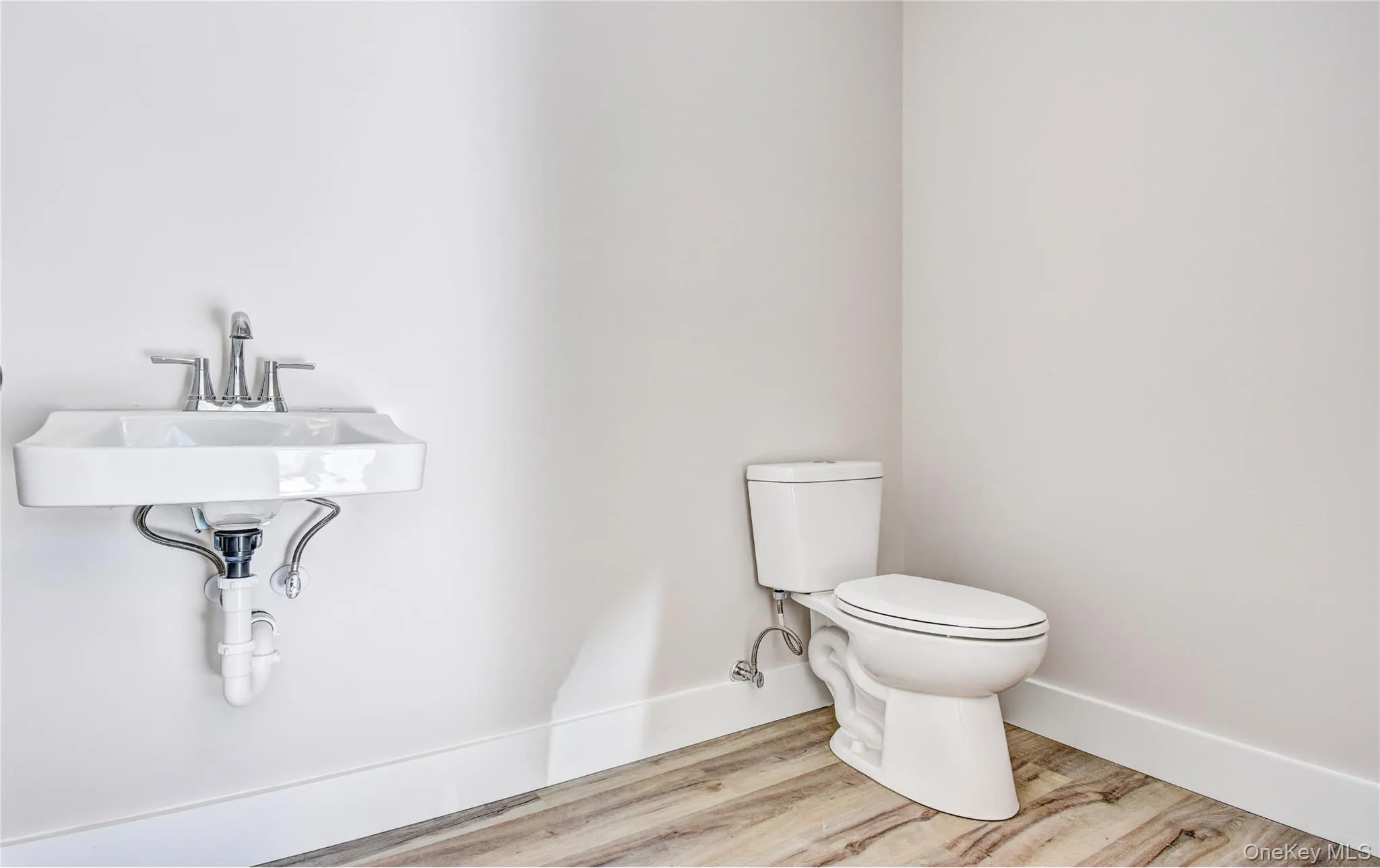 Half bath with wood finished floors and toilet Half bath with wood finished floors and toilet