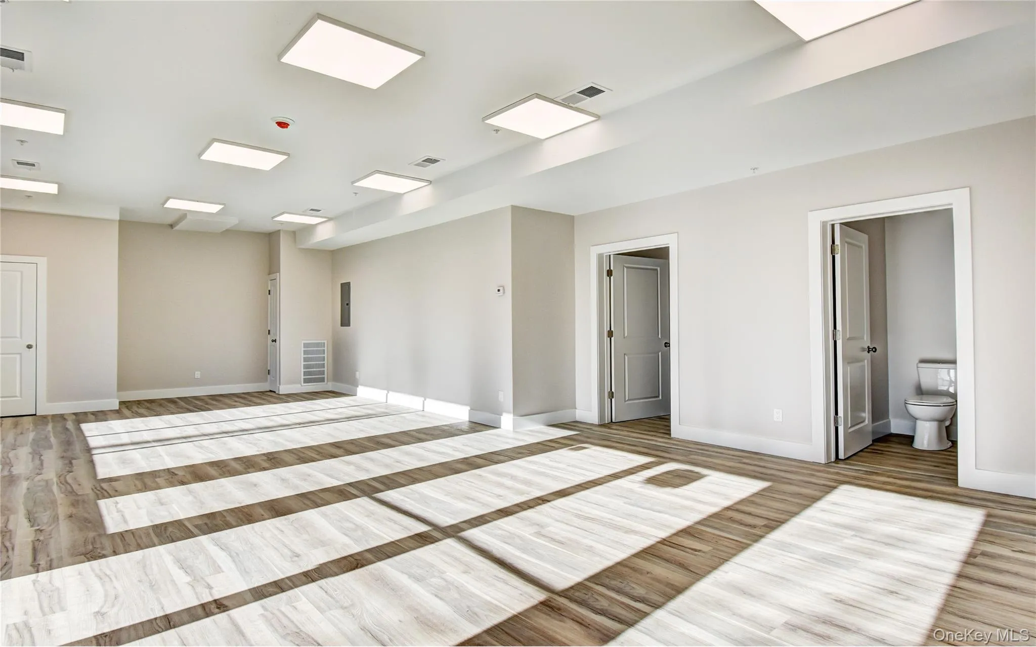 Unfurnished room with light wood-style flooring and baseboards Unfurnished room with light wood-style flooring and baseboards