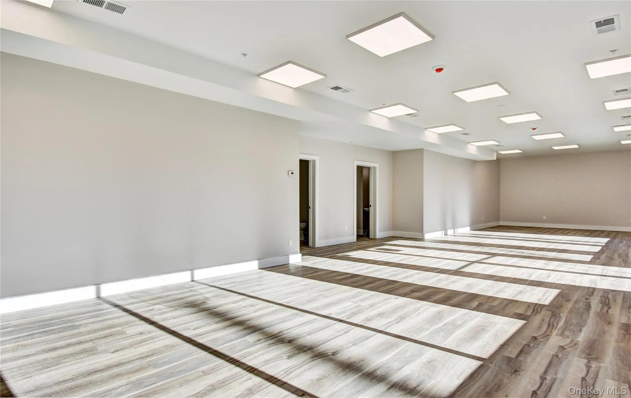 Spare room with wood finished floors and baseboards Spare room with wood finished floors and baseboards