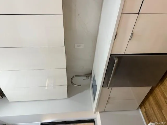 Kitchen featuring white cabinetry, modern cabinets, dishwashing machine, and light wood-style floors Kitchen featuring white cabinetry, modern cabinets, dishwashing machine, and light wood-style floors