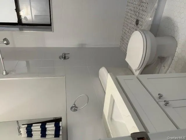 Bathroom featuring a stall shower, tile walls, and vanity Bathroom featuring a stall shower, tile walls, and vanity