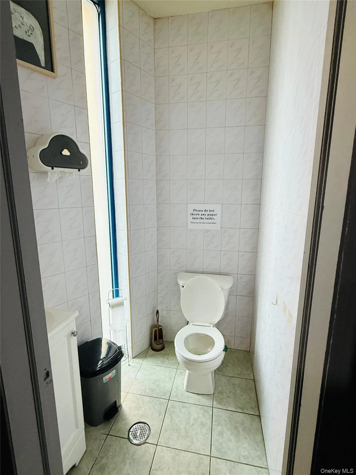 Bathroom featuring tile walls, light tile patterned floors, and vanity Bathroom featuring tile walls, light tile patterned floors, and vanity