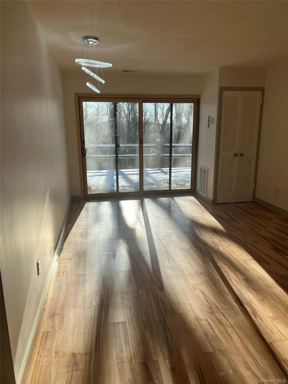 Empty room featuring hardwood / wood-style flooring and a textured ceiling Empty room featuring hardwood / wood-style flooring and a textured ceiling