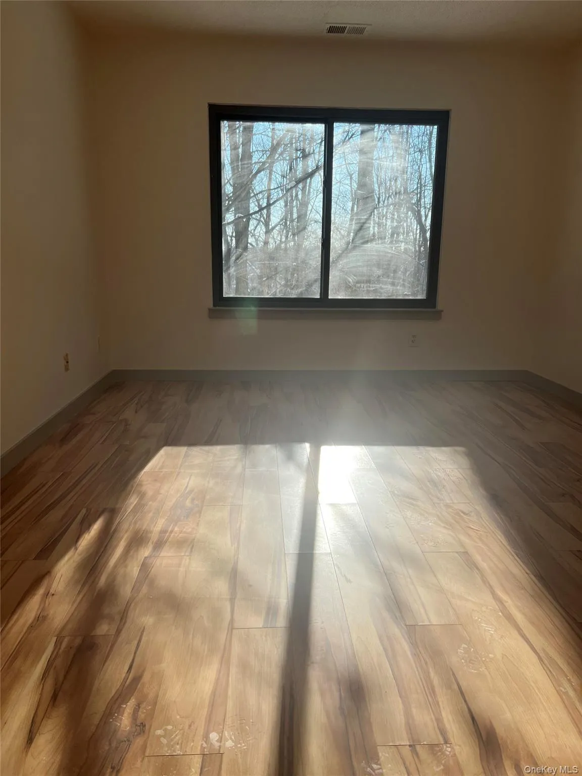 Spare room with light wood-style flooring and baseboards Spare room with light wood-style flooring and baseboards