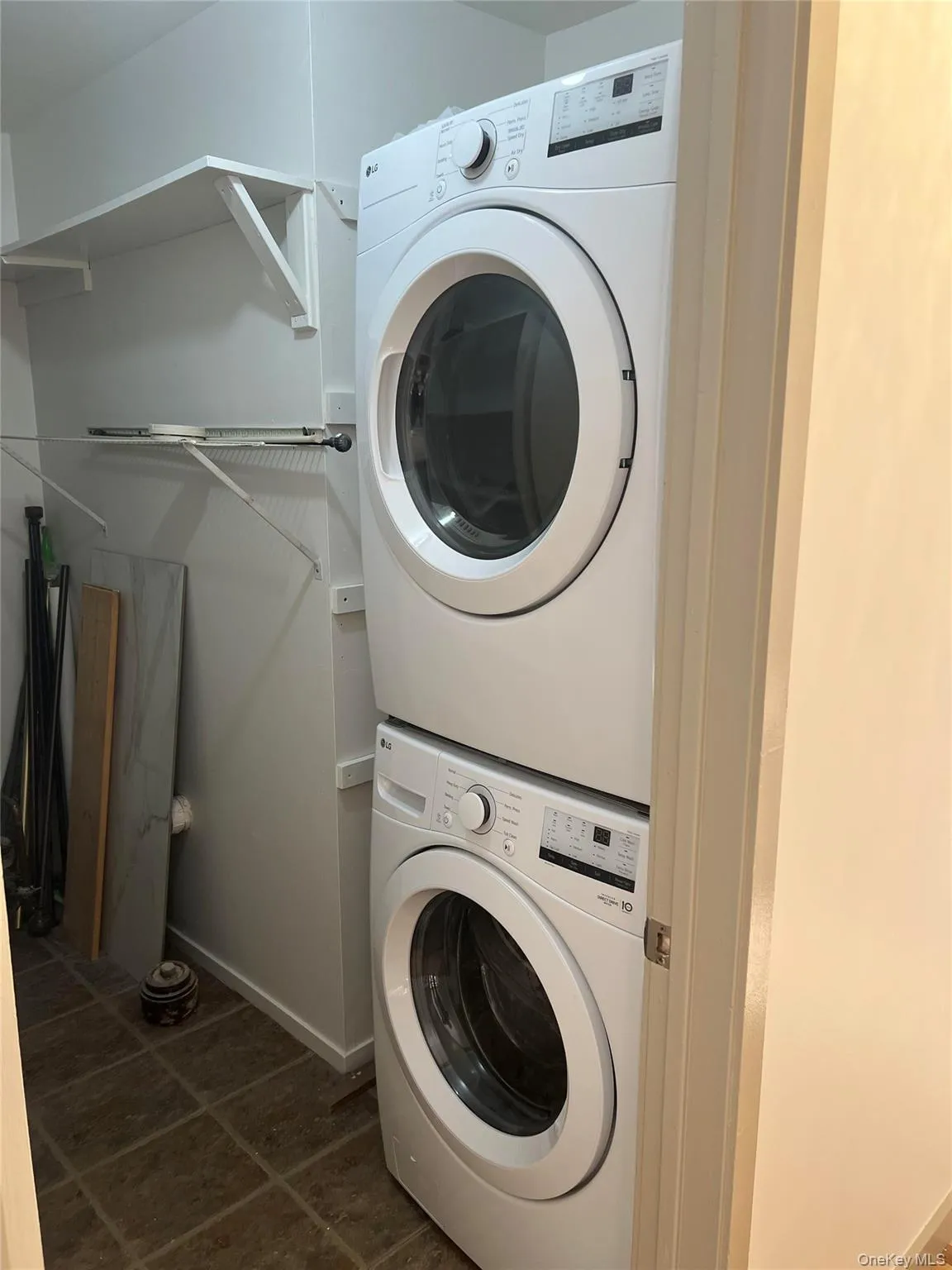 Laundry area with stacked washer / drying machine and baseboards Laundry area with stacked washer / drying machine and baseboards