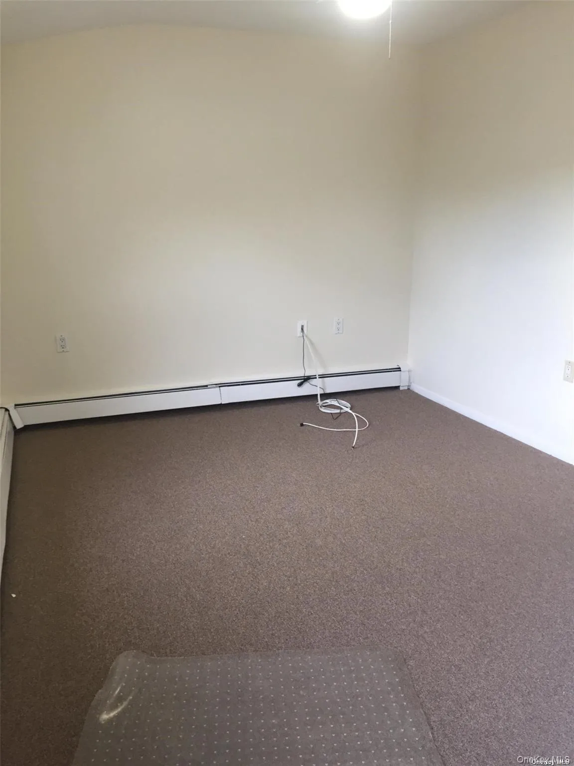 Unfurnished room with a baseboard heating unit and carpet flooring Unfurnished room with a baseboard heating unit and carpet flooring