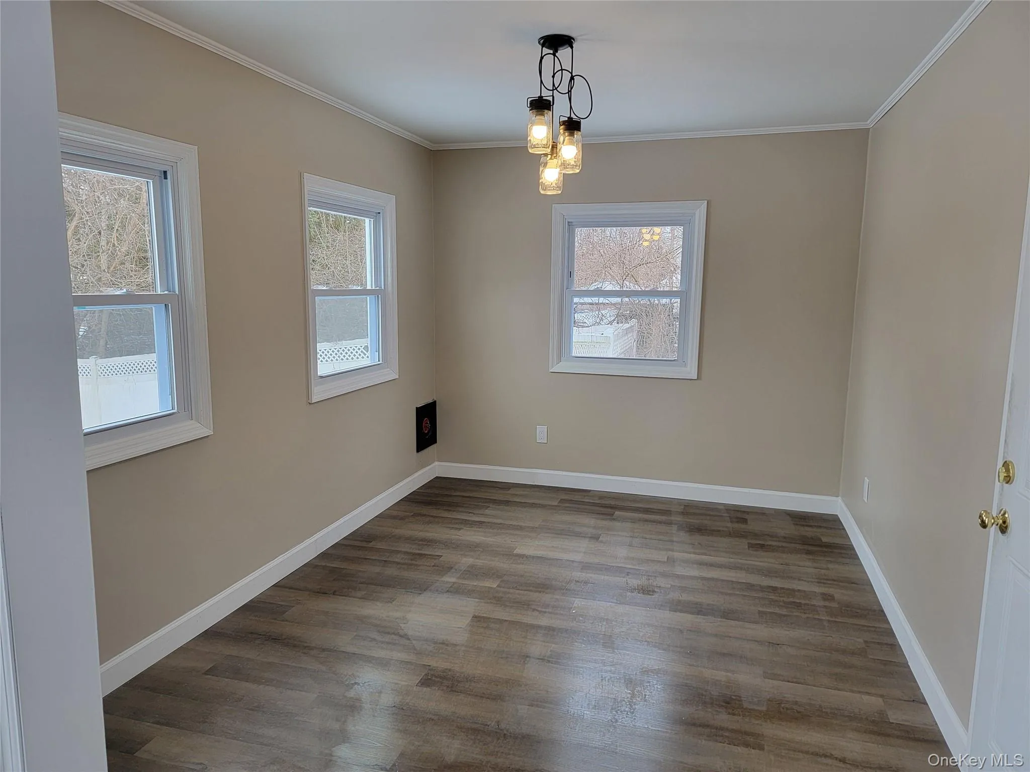 Dining room featuring light wood-style flooring, ornamental molding, and a light Dining room featuring light wood-style flooring, ornamental molding, and a light
