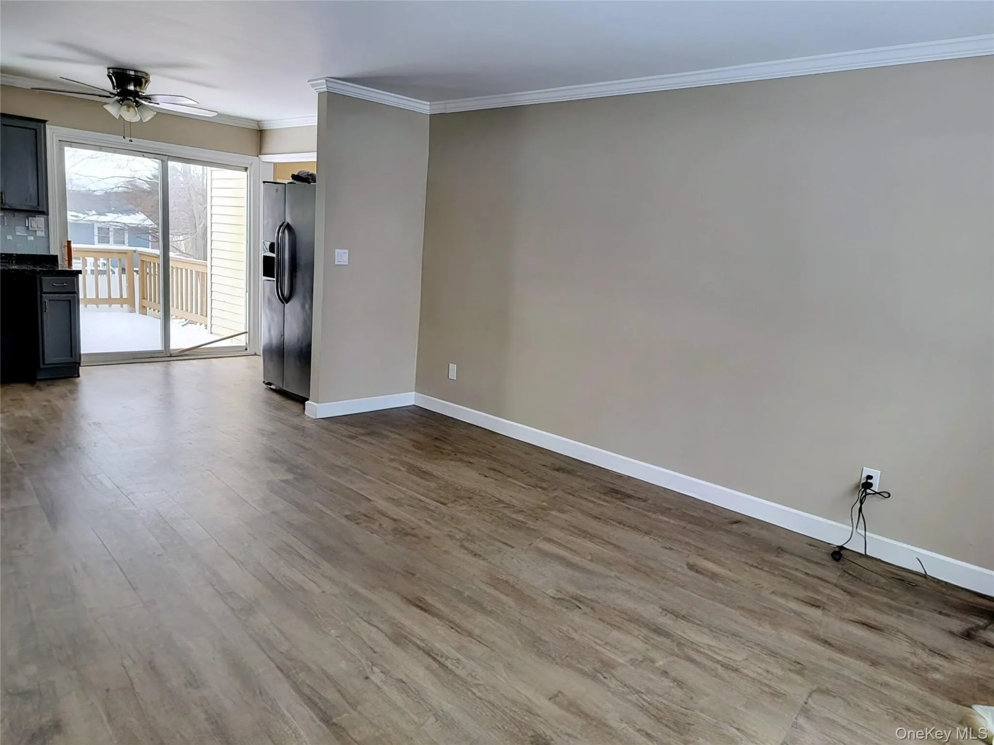 Unfurnished living room with ornamental molding, light wood finished floors, and a ceiling fan Unfurnished living room with ornamental molding, light wood finished floors, and a ceiling fan