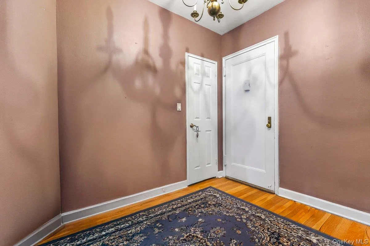 Foyer entrance featuring wood finished floors and a chandelier Foyer entrance featuring wood finished floors and a chandelier