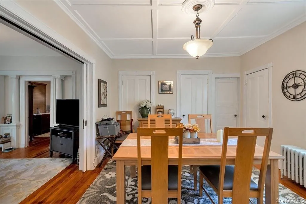 Dining area featuring wood finished floors and radiator Dining area featuring wood finished floors and radiator