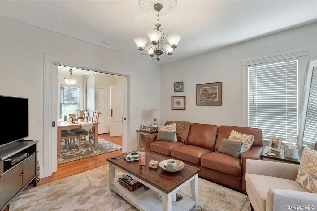 Living room featuring wood finished floors and a chandelier Living room featuring wood finished floors and a chandelier
