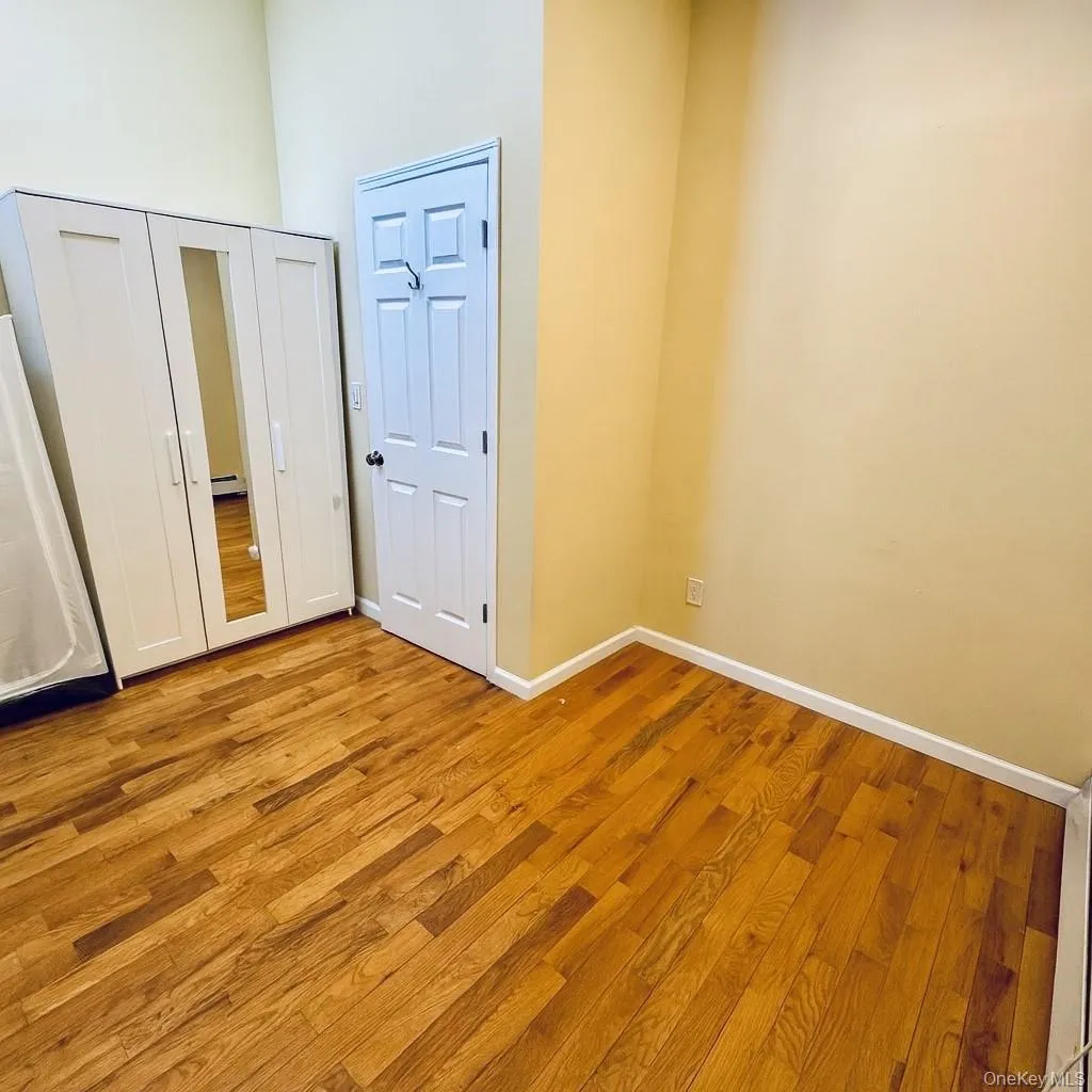 Unfurnished bedroom with light wood-style flooring, a closet, and a high ceiling Unfurnished bedroom with light wood-style flooring, a closet, and a high ceiling