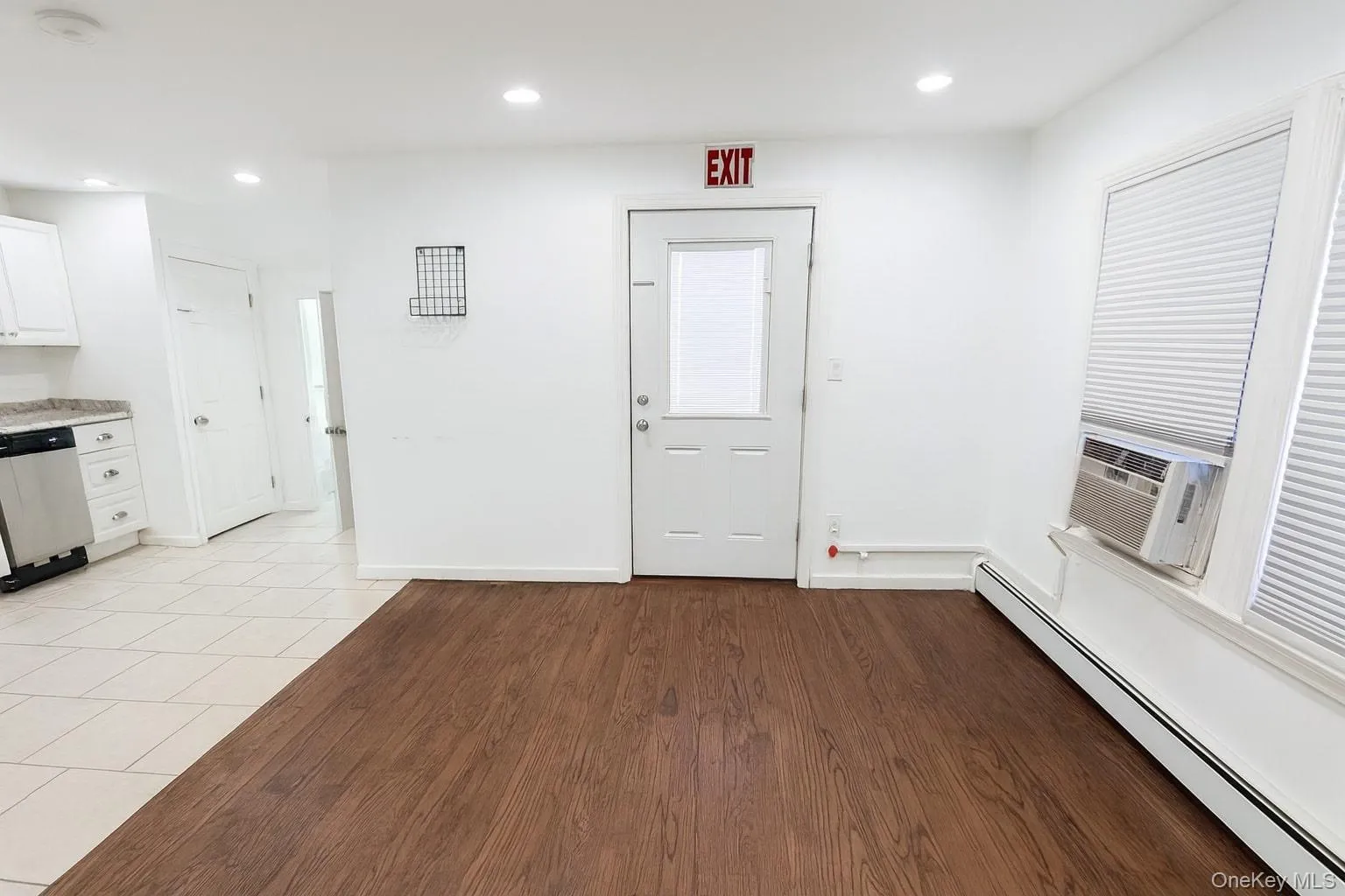 Foyer featuring baseboard heating, recessed lighting, cooling unit, and light wood-style floors Foyer featuring baseboard heating, recessed lighting, cooling unit, and light wood-style floors