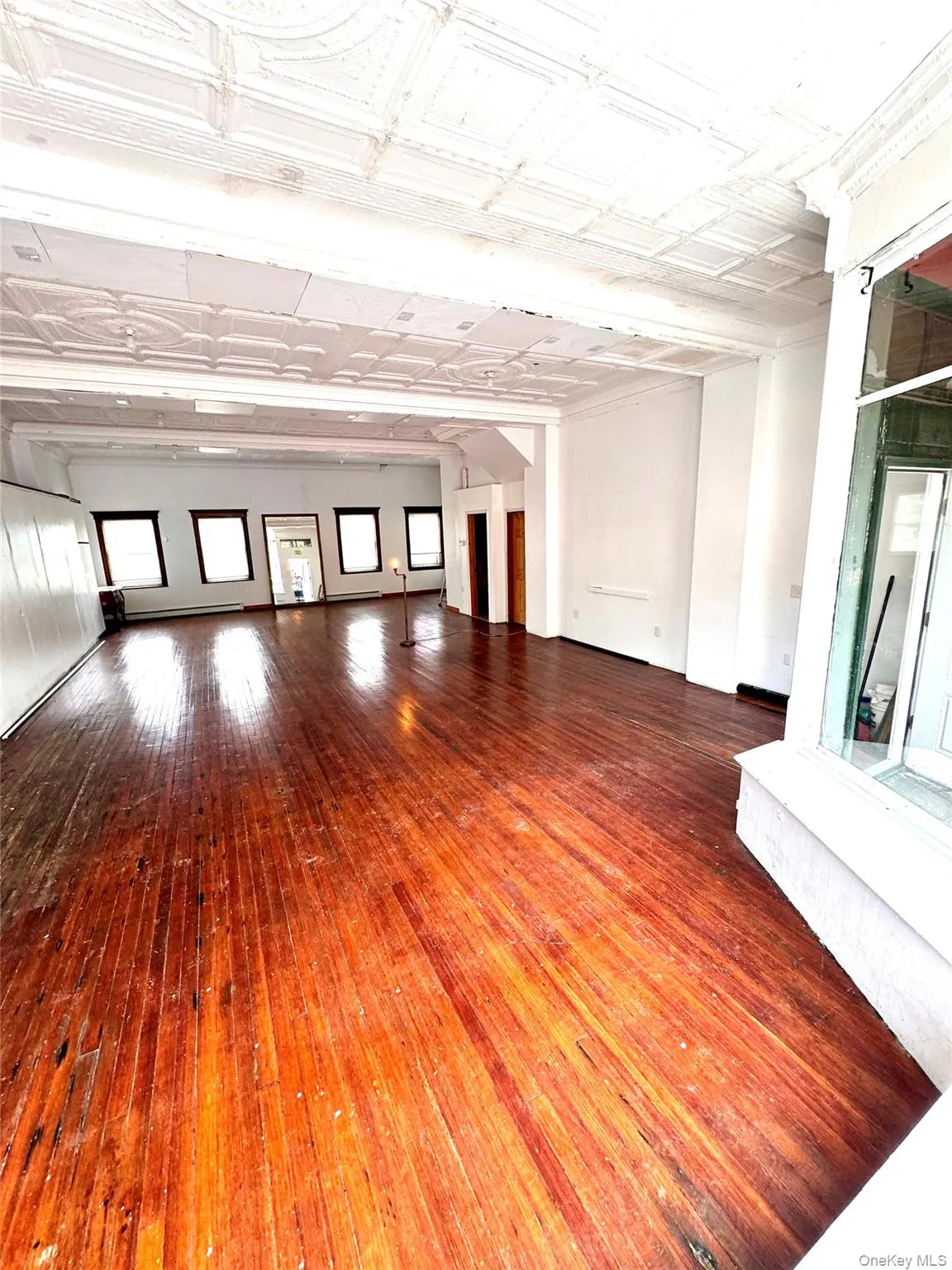 Unfurnished living room featuring an ornate ceiling and dark wood-style flooring Unfurnished living room featuring an ornate ceiling and dark wood-style flooring
