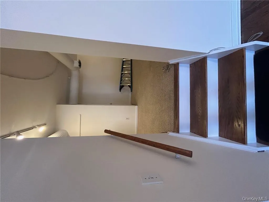 Stairway featuring hardwood / wood-style floors and track lighting Stairway featuring hardwood / wood-style floors and track lighting